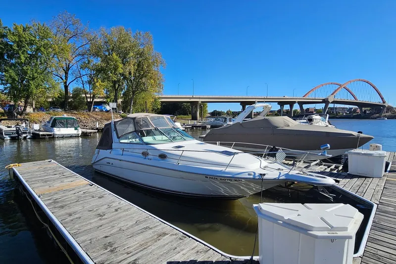 The Image of 1996 Sea Ray 290 Sundancer docked at marina with bridge in background. - 1
