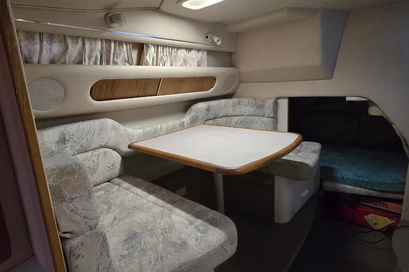Slide: The Image of 1996 Sea Ray 290 Sundancer cabin interior with dining area and seating. - 3