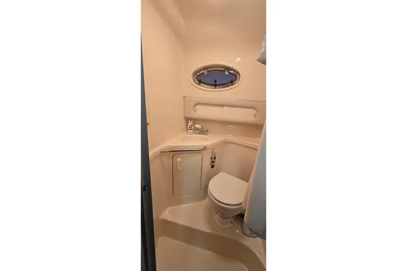 Slide: The Image of 1996 Sea Ray 290 Sundancer bathroom with compact design and porthole window. - 6