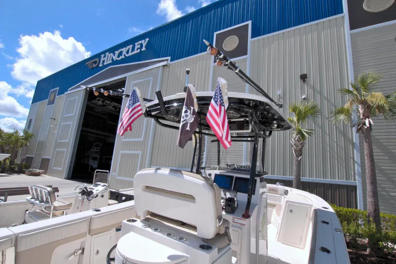 Slide: The Image of 2018 Sea Chaser 27 HFC boat docked outside Hinckley building with flags. - 11