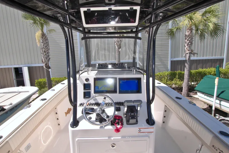 Slide: The Image of 2018 Sea Chaser 27 HFC boat console with steering wheel and navigation screens. - 21