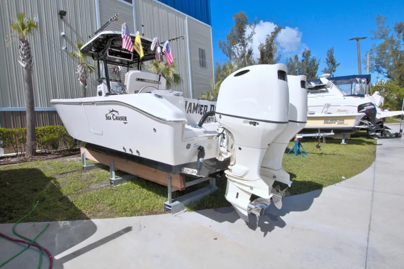 Slide: The Image of 2018 Sea Chaser 27 HFC boat on display outdoors with flags. - 3