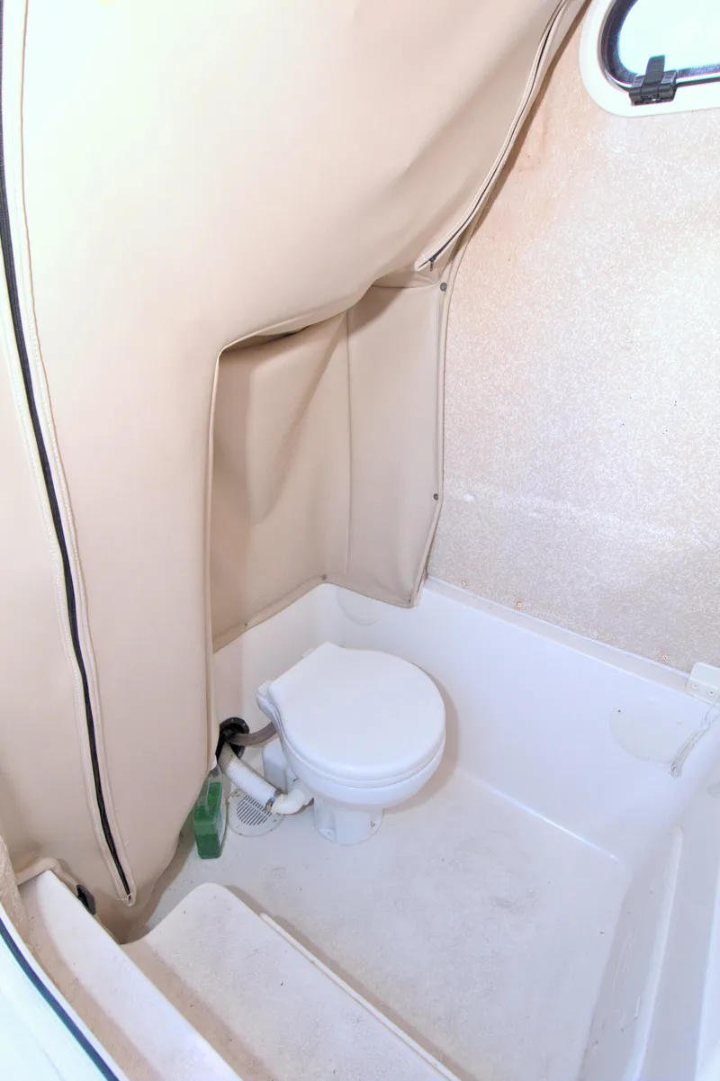 Slide: The Image of 2018 Sea Chaser 27 HFC boat interior bathroom with toilet and beige walls. - 31
