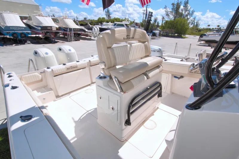 Slide: The Image of 2018 Sea Chaser 27 HFC boat interior with seating and controls, docked under clear skies. - 33
