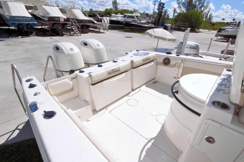 Slide: The Image of 2018 Sea Chaser 27 HFC boat interior with dual engines, docked outdoors. - 34