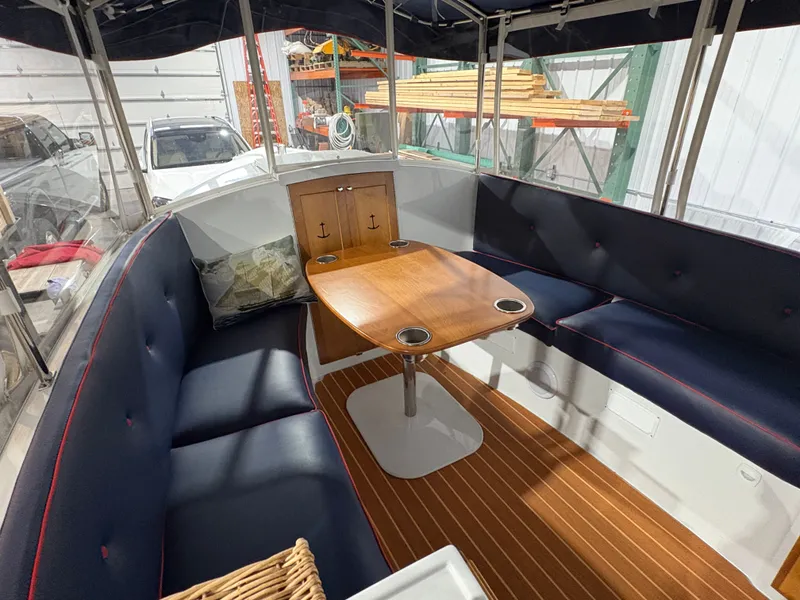 Slide: The Image of Interior of a 2021 Duffy Cuddy Cabin with wooden table and blue seating. - 33