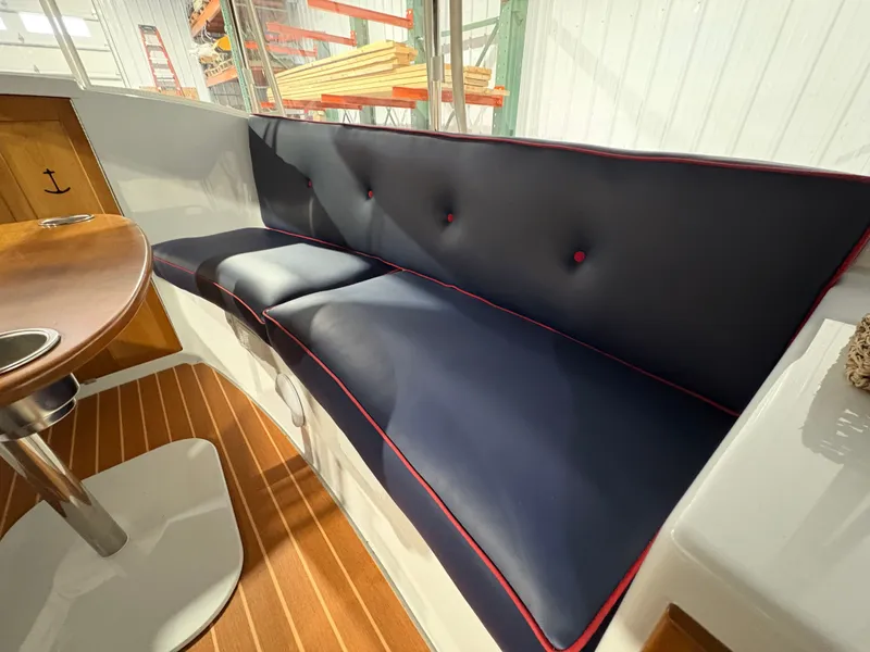 Slide: The Image of Interior of 2021 Duffy Cuddy Cabin with blue cushioned seating. - 34