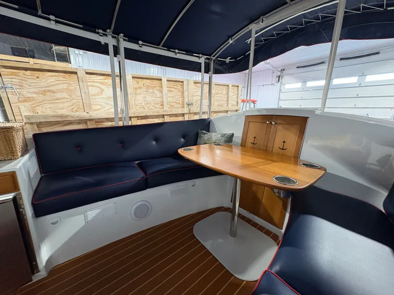 Slide: The Image of Interior of a 2021 Duffy Cuddy Cabin with wooden table and blue seating. - 35