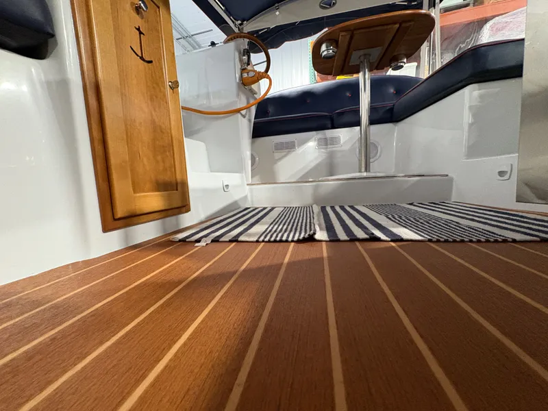 Slide: The Image of Interior of 2021 Duffy Cuddy Cabin with wooden floor and blue seating. - 47