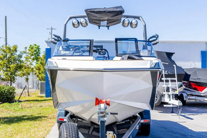 Slide: The Image of 2022 Nautique Super Air Nautique G23 boat on trailer, front view, outdoors. - 15