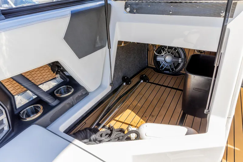 Slide: The Image of 2022 Nautique Super Air Nautique G23 interior storage with speaker and cup holders. - 16