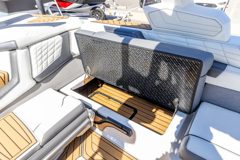 Slide: The Image of 2022 Nautique Super Air Nautique G23 interior with open storage compartment and luxury seating. - 18