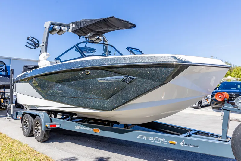 Slide: The Image of 2022 Nautique Super Air Nautique G23 boat on trailer, parked outdoors. - 19