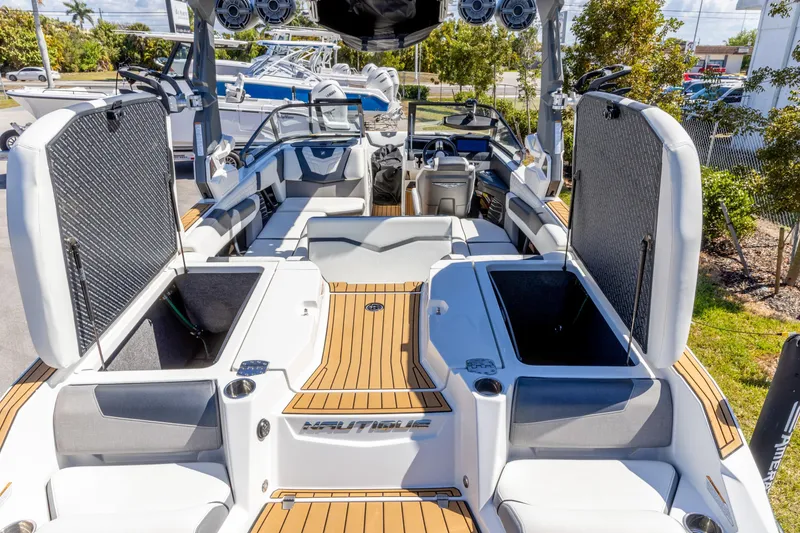 Slide: The Image of 2022 Nautique Super Air Nautique G23 interior with open storage compartments and seating. - 22