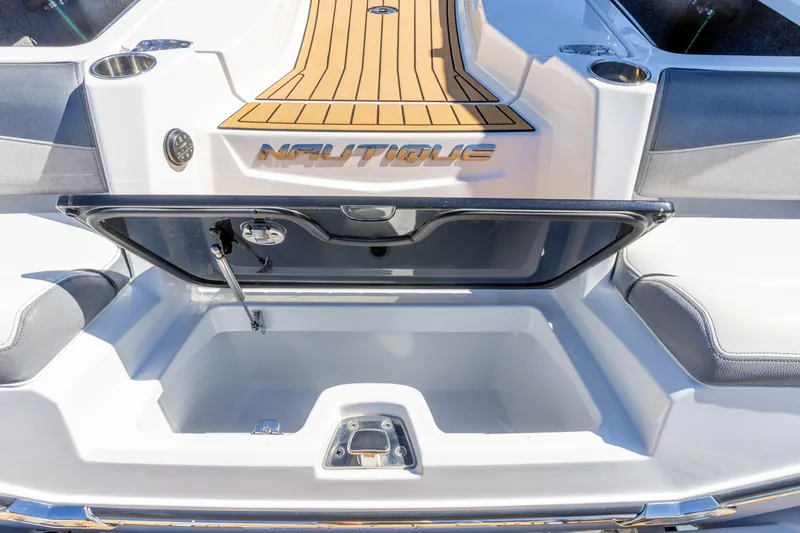 Slide: The Image of 2022 Nautique Super Air Nautique G23 boat storage compartment open, showcasing interior space. - 24