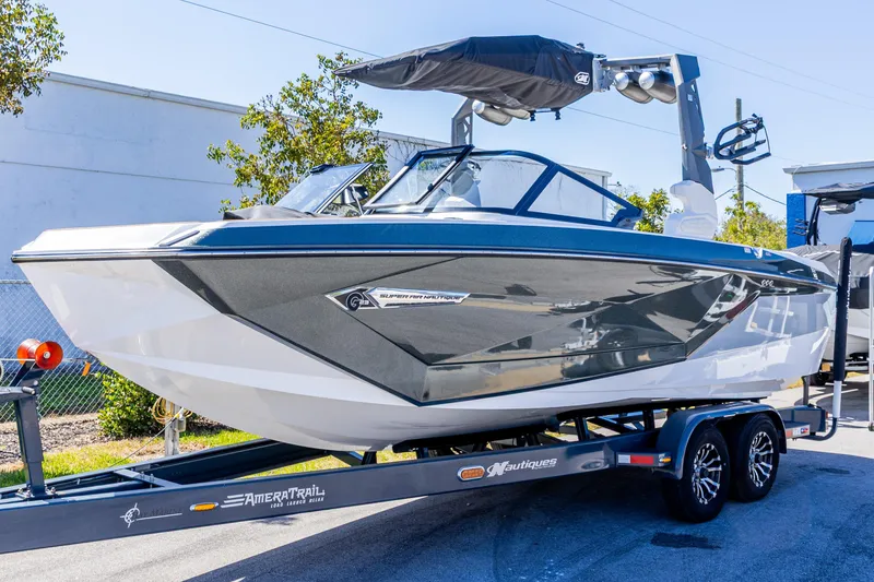 Slide: The Image of 2022 Nautique Super Air Nautique G23 boat on trailer, sleek design, outdoor display. - 27