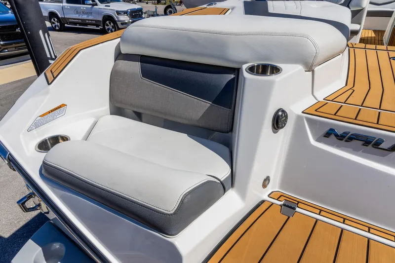 Slide: The Image of 2022 Nautique Super Air Nautique G23 boat interior with cushioned seating and teak flooring. - 3