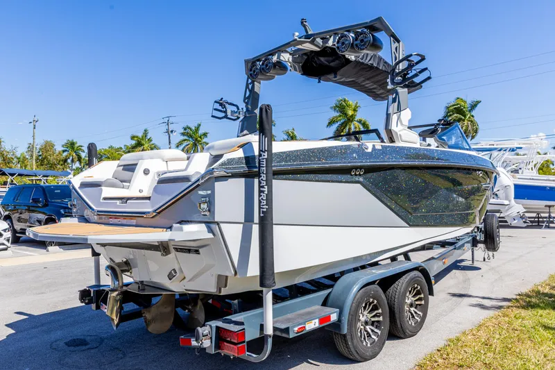 Slide: The Image of 2022 Nautique Super Air Nautique G23 boat on trailer, sunny day, palm trees background. - 7