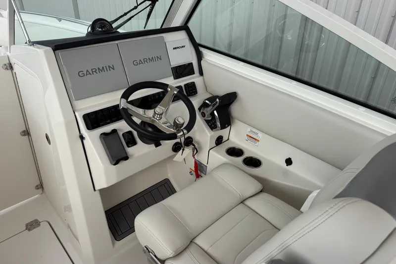 Slide: The Image of 2026 Sailfish 276 DC boat helm with Garmin displays and Mercury controls. - 16