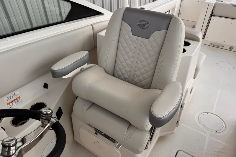 Slide: The Image of Captain's chair on 2026 Sailfish 276 DC boat, featuring luxurious gray upholstery and armrests. - 17