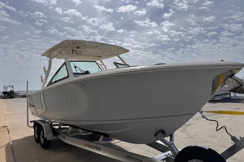 Slide: The Image of 2026 Sailfish 276 DC boat on trailer under cloudy sky. - 6