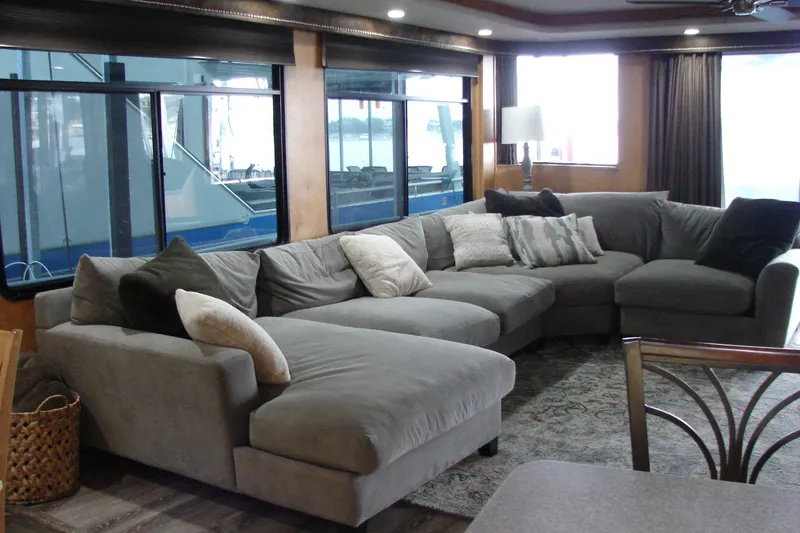 Slide: The Image of Luxurious living area in a 1999 Sumerset 18x90 houseboat with a large gray sectional sofa. - 11