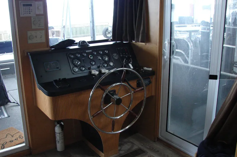 Slide: The Image of Control panel of a 1999 Sumerset 18x90 houseboat with steering wheel and gauges. - 13