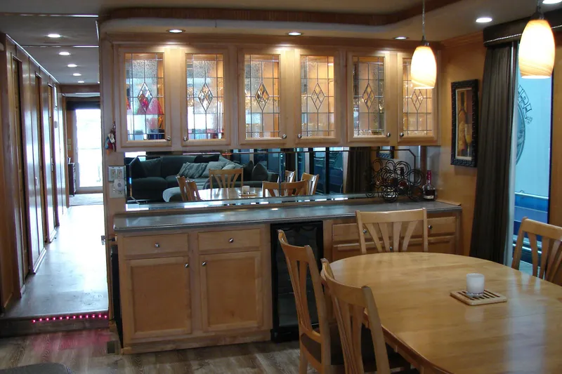 Slide: The Image of Interior of 1999 Sumerset 18x90 houseboat with wooden cabinets and dining area. - 15