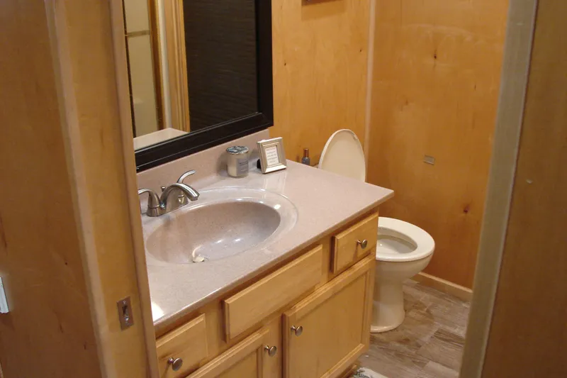 Slide: The Image of Bathroom interior of 1999 Sumerset 18x90 houseboat with wooden cabinetry and modern fixtures. - 18