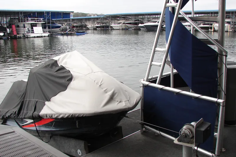 Slide: The Image of Covered boat docked at marina, Sumerset 18x90, 1999 model in the background. - 19