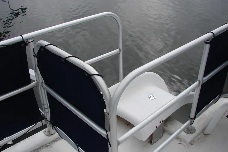 Slide: The Image of Rear deck view of a 1999 Sumerset 18x90 houseboat with railing and water backdrop. - 29