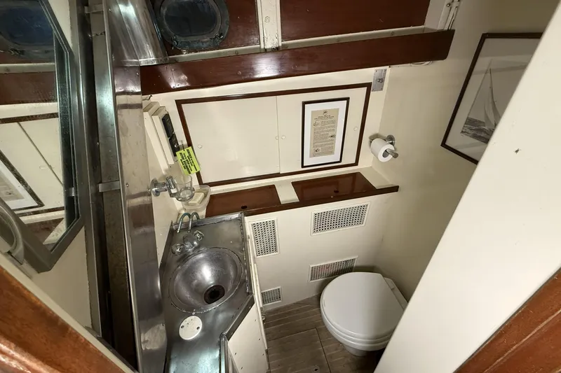 Slide: The Image of 1959 Sparkman & Stephens Custom 46 yacht bathroom with sink, toilet, and wooden accents. - 18
