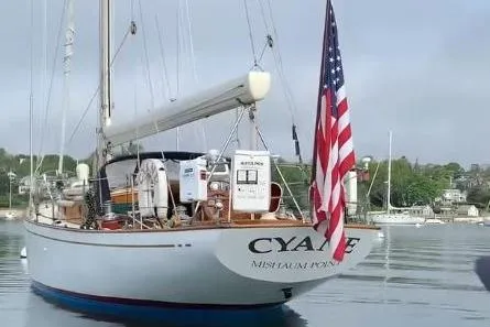 Slide: The Image of 1959 Sparkman & Stephens Custom 46 sailboat with American flag, docked in calm waters. - 6