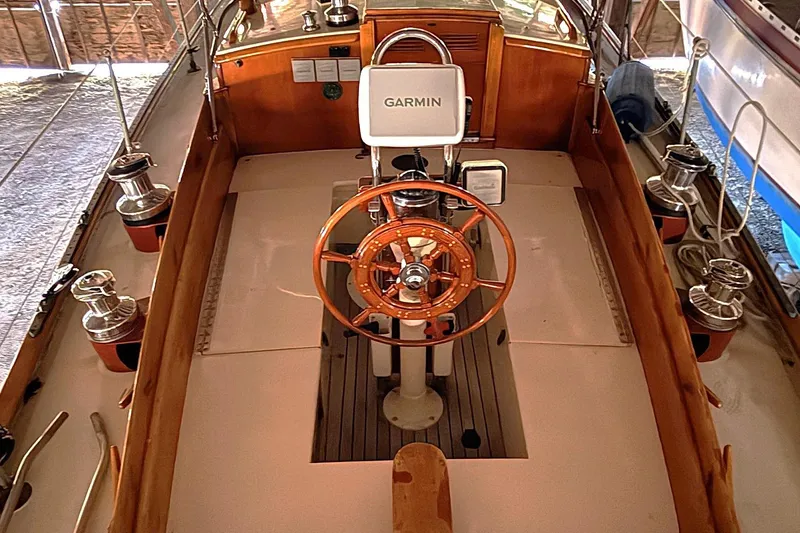 Slide: The Image of 1959 Sparkman & Stephens Custom 46 sailboat cockpit with wooden wheel and Garmin navigation. - 8