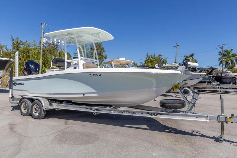 Slide: The Image of 2022 Crevalle 24 HCO boat on trailer, parked outdoors under clear blue sky. - 11