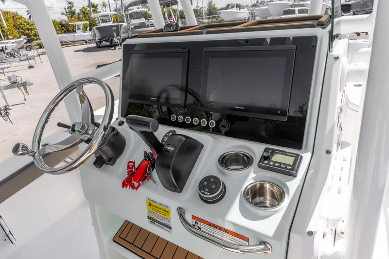 Slide: The Image of 2022 Crevalle 24 HCO boat console with steering wheel, dual screens, and control panel. - 17