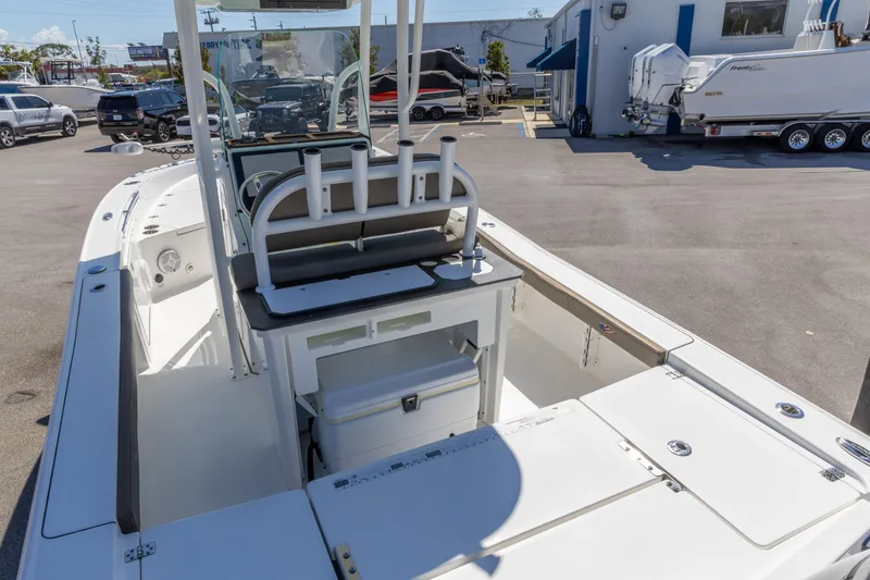 Slide: The Image of 2022 Crevalle 24 HCO boat interior with seating and storage, parked outdoors. - 4