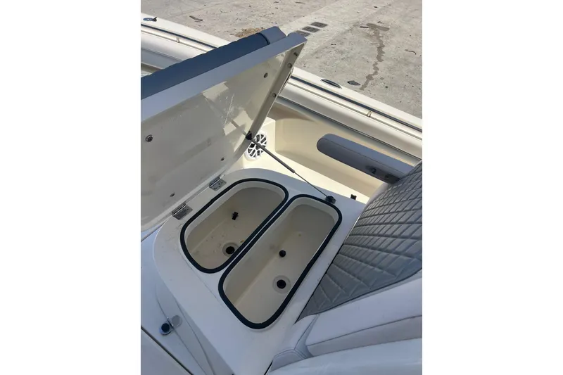 Slide: The Image of Open storage compartment on 2026 Blackwood 270 boat, featuring dual bins and cushioned seating. - 9
