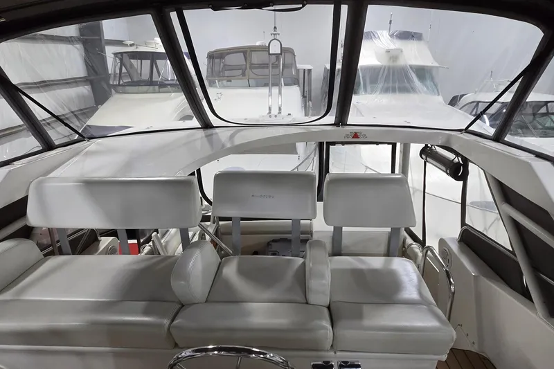 Slide: The Image of 1998 Silverton 322 Motor Yacht interior with white seating and large windows. - 11