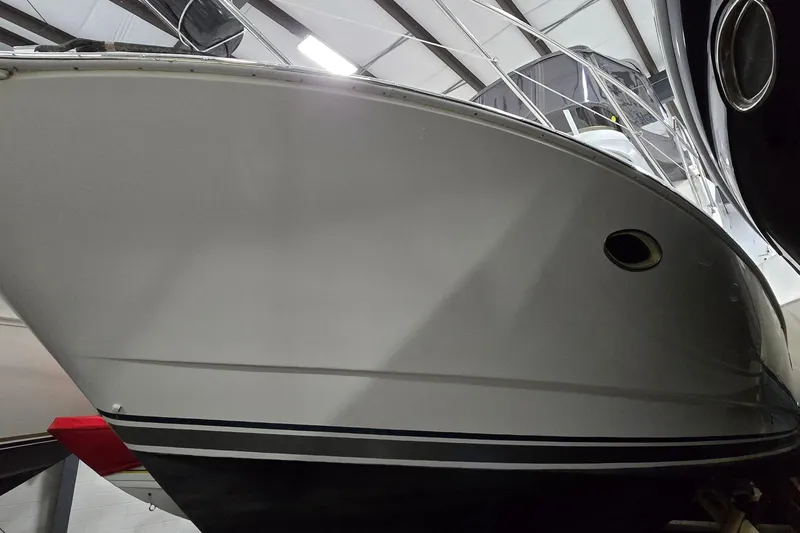 Slide: The Image of 1998 Silverton 322 Motor Yacht in indoor storage, showcasing sleek hull design. - 2