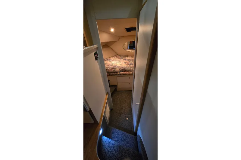 Slide: The Image of 1998 Silverton 322 Motor Yacht interior cabin with bed and carpeted stairs. - 29