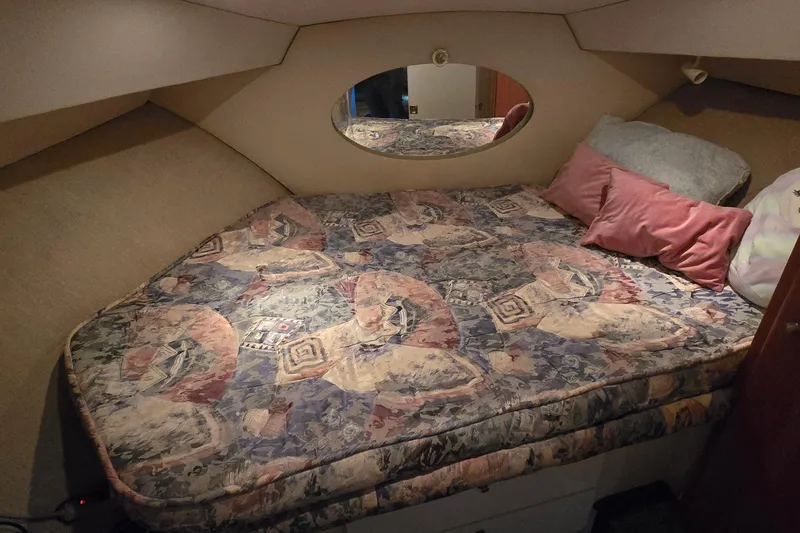 Slide: The Image of 1998 Silverton 322 Motor Yacht cabin with patterned bedding and pillows. - 30