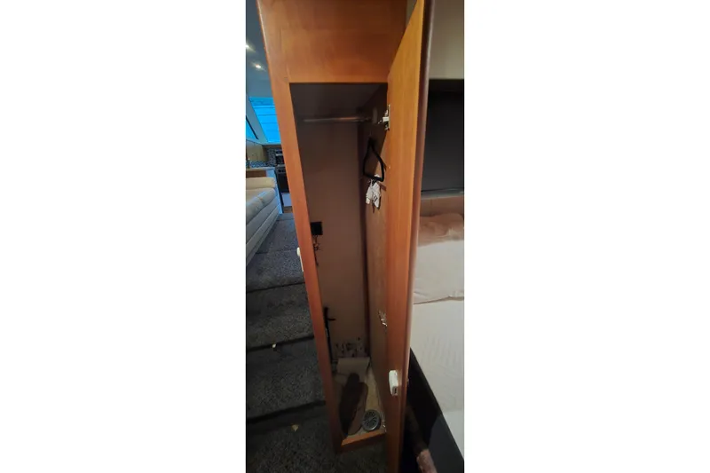 Slide: The Image of Interior view of a 1998 Silverton 322 Motor Yacht closet with hangers. - 42