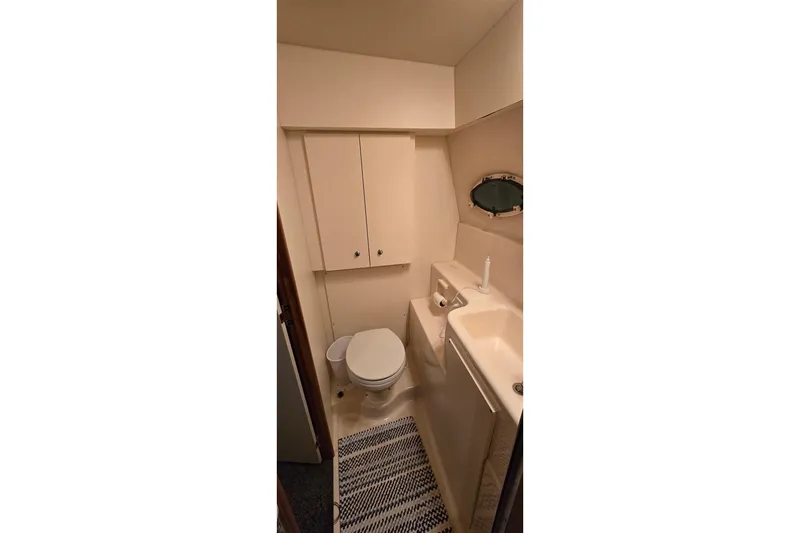 Slide: The Image of Bathroom interior of 1998 Silverton 322 Motor Yacht, featuring toilet and sink. - 48