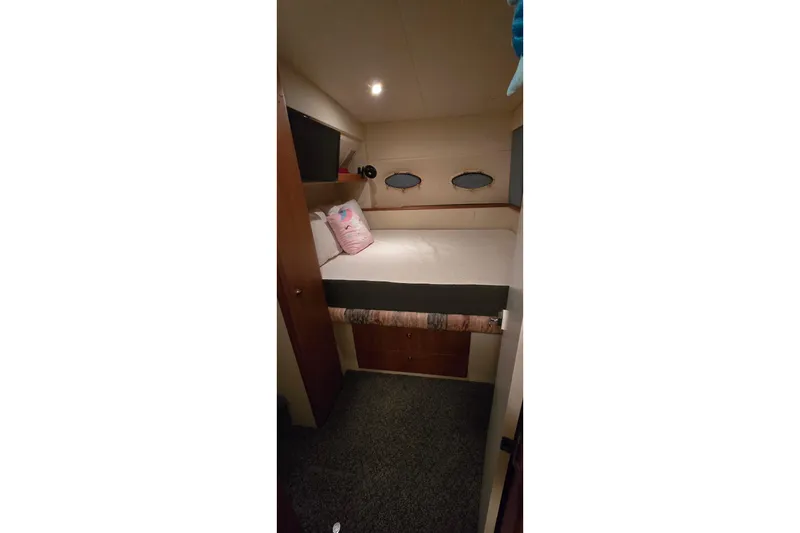 Slide: The Image of Cozy cabin interior of 1998 Silverton 322 Motor Yacht with bed and portholes. - 49