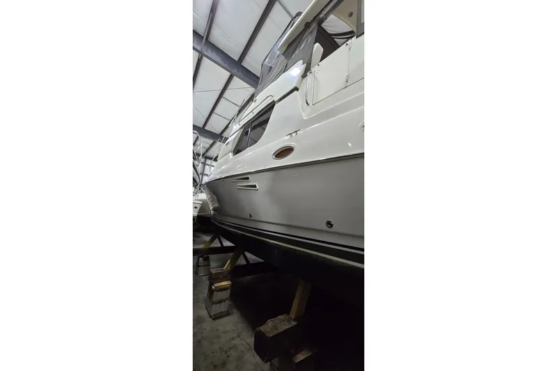 Slide: The Image of 1998 Silverton 322 Motor Yacht in storage, side view in a warehouse setting. - 5