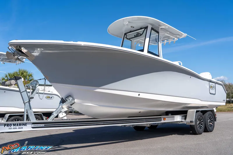 Slide: The Image of 2026 Sea Hunt Ultra 265 SE boat on trailer under clear blue sky. - 10