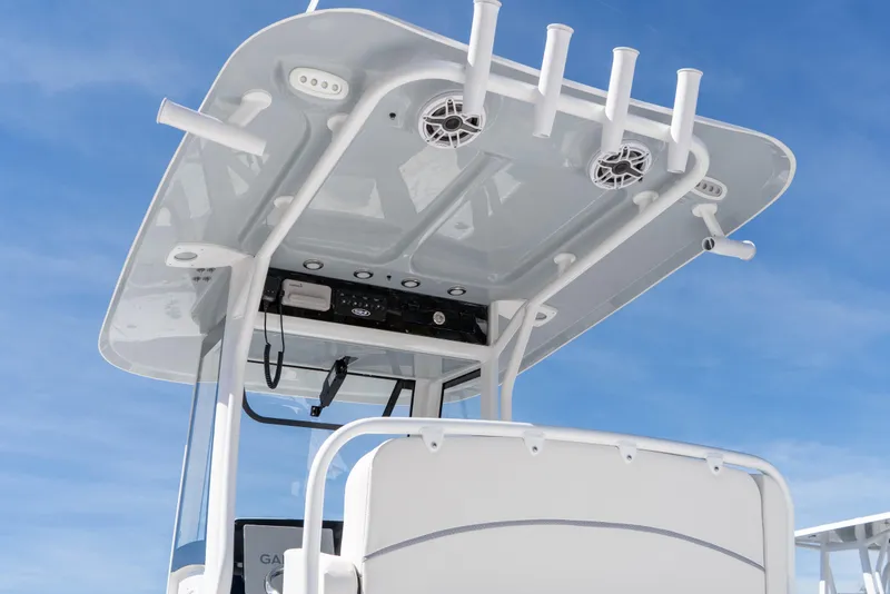 Slide: The Image of 2026 Sea Hunt Ultra 265 SE boat with T-top and rod holders against blue sky. - 13