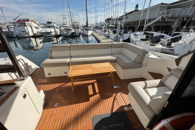 Slide: The Image of 2020 Beneteau Monte Carlo 52 yacht deck with seating and table at marina. - 10