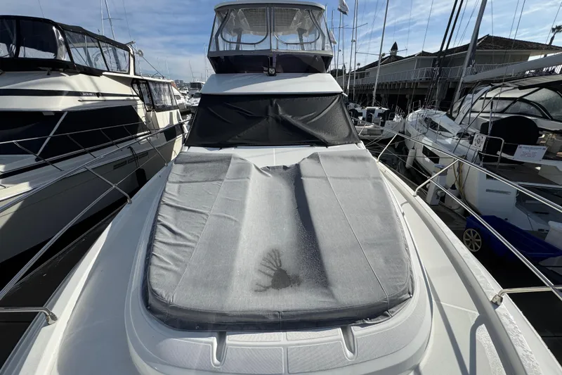 Slide: The Image of 2020 Beneteau Monte Carlo 52 yacht with covered deck, docked among other boats. - 39